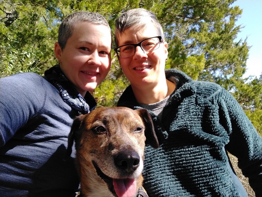 Casady and her wife, Molly, pose with their dog Rocket while on a hike in South Carolina. All three are looking to camera, smiling. 